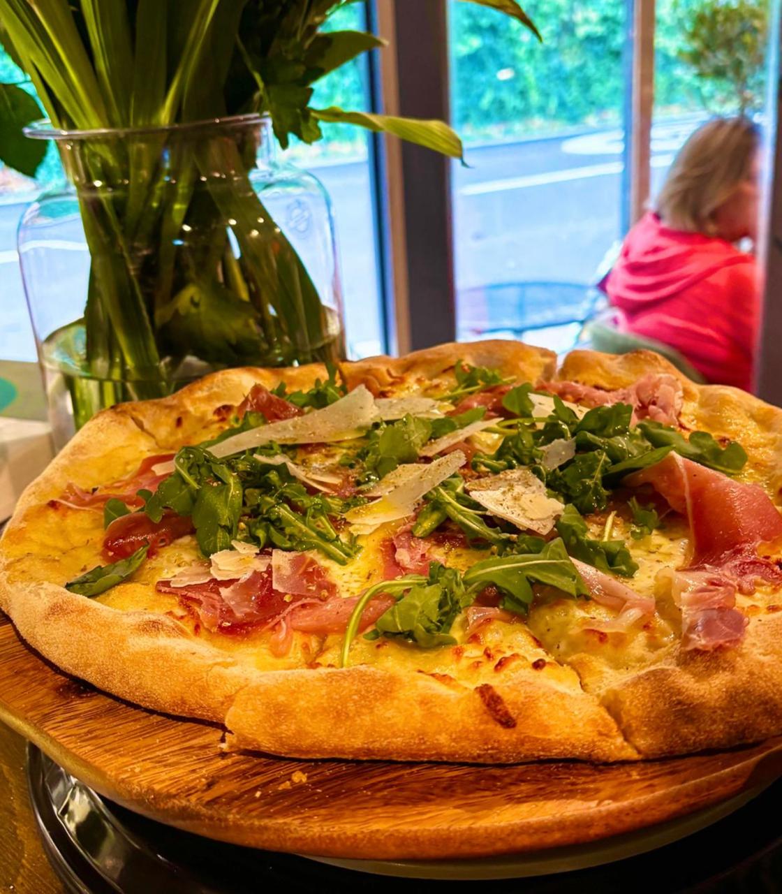 Artisan pizza with prosciutto, arugula and parmesan